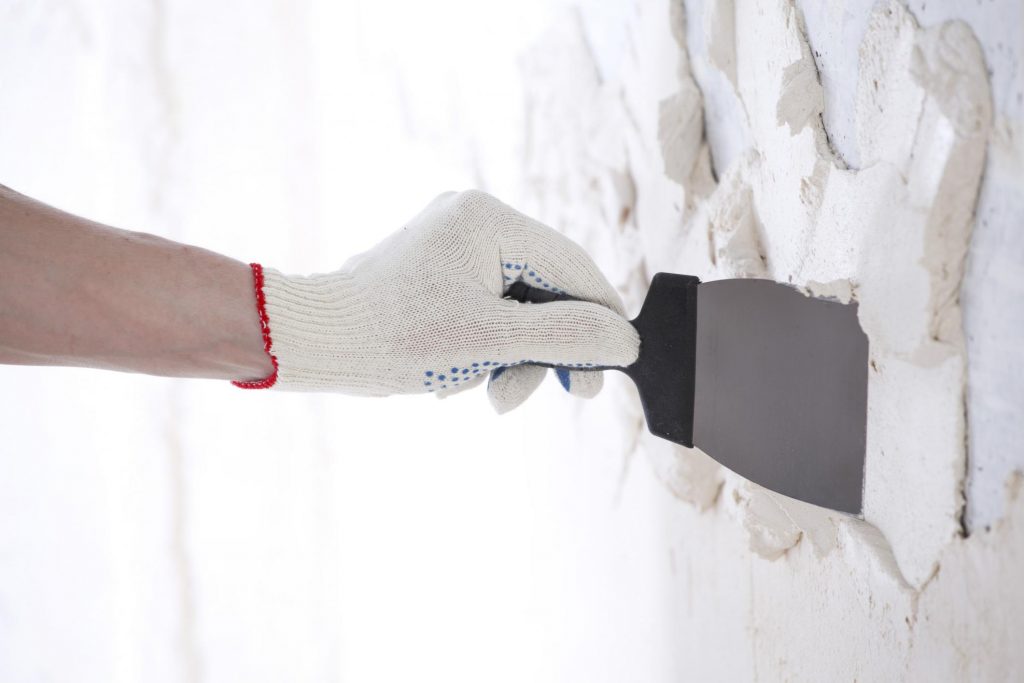 man applying white plasters on the wall